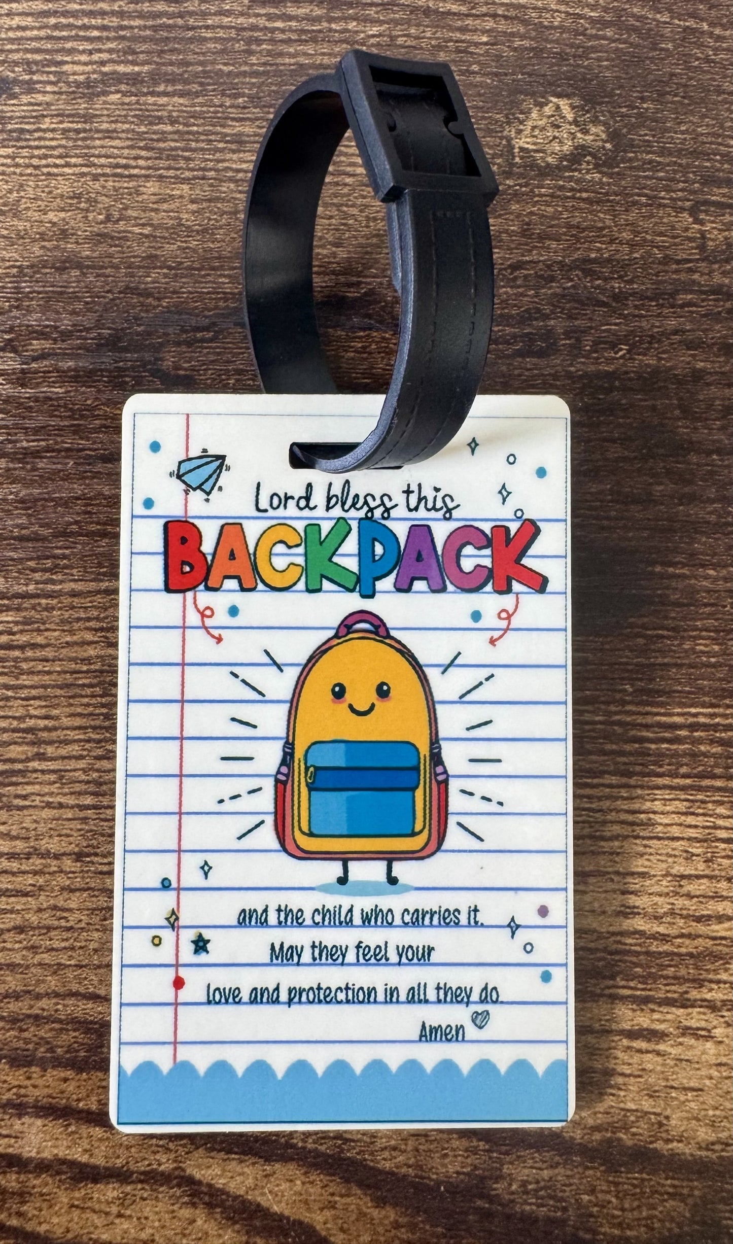Luggage tag with a backpack illustration and text on a wooden surface